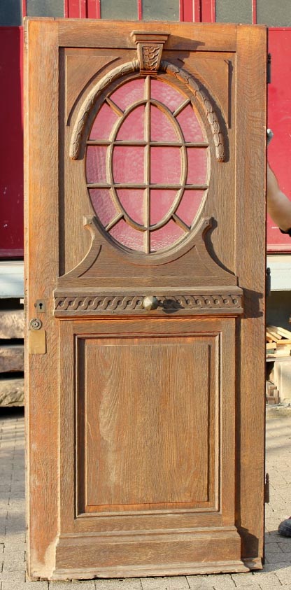 Oude eiken voordeur met ovaal roedenvenster in rood glas, het voorbeeld voor de replica
